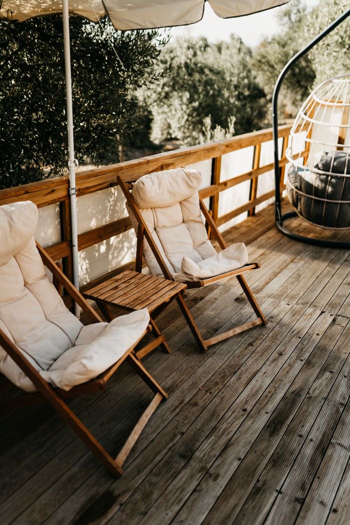Peaceful terrace setting with wooden sun loungers and umbrella in Ortaca, Türkiye.