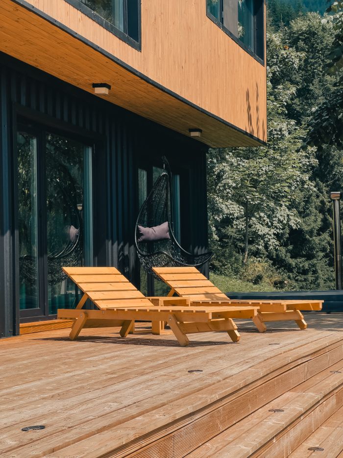 Contemporary patio setup with sun loungers beside a modern house.