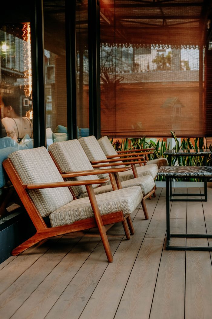 Stylish wooden chairs with cushions on a modern outdoor patio, perfect for relaxation.